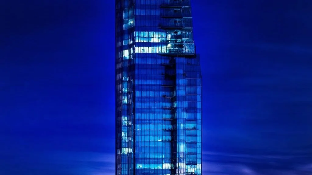 Illuminated glass skyscraper at dusk